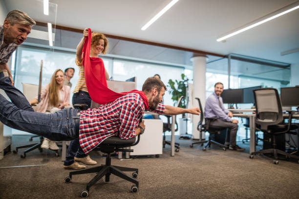 gruppe von verspielten kollegen spaß auf eine pause im casual büro. - pushing men people business stock-fotos und bilder