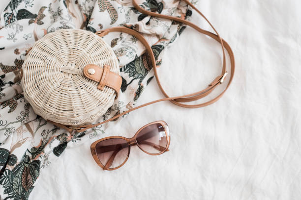 istock Round ladys wickered straw handbag on white linen 973095872