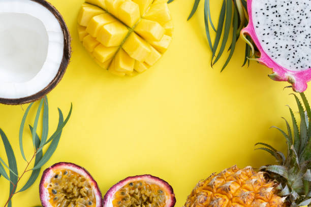 istock Tropical fruits mango, pitayam coconut and passion fruit on yellow background 973095924