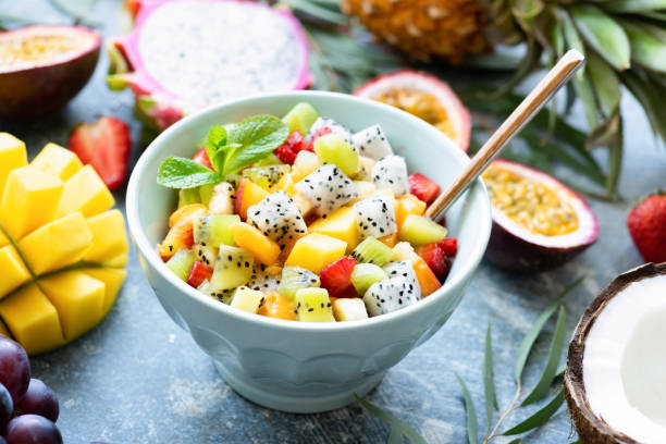 istock Fruit salad with tropical fruits mango, coconut, pitaya in a bowl 973096038