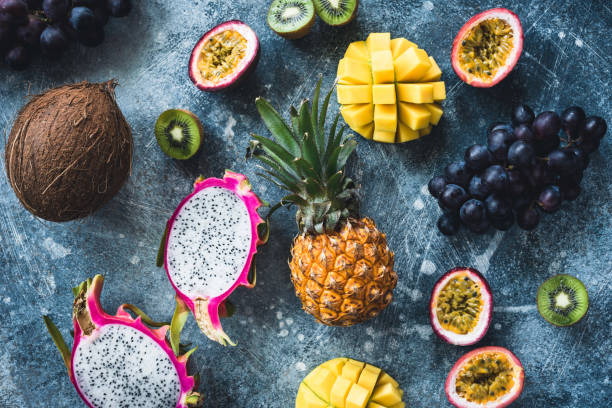 istock Tropical fruits on stone background, flat lay 973096066
