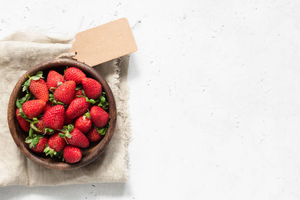 istock Strawberry in bowl. Fresh strawberries on white concrete background 973096086