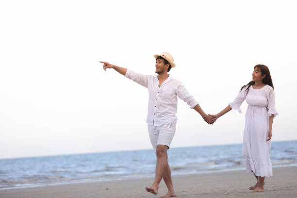 istock Happy Romantic Couples lover holding hands together walking on the beach 973096624
