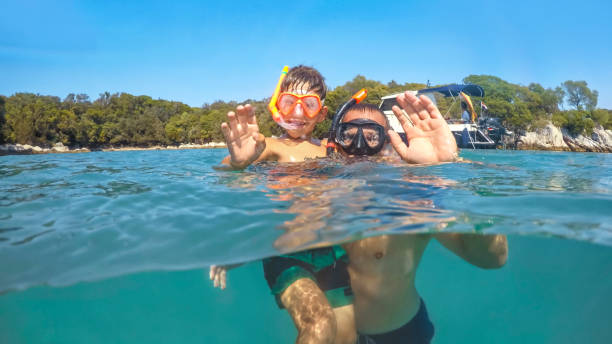 istock Father and son swimming in sea 973099008