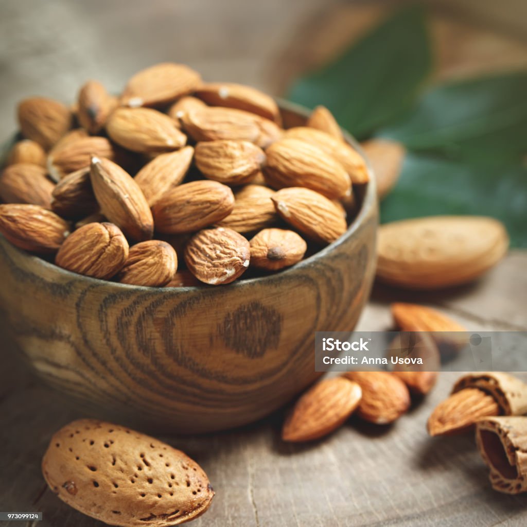 Almond on a wooden table in the summer garden. Useful food Almond on a wooden table in the summer garden. Useful food. Healthy lifestyle. Merchandise Stock Photo