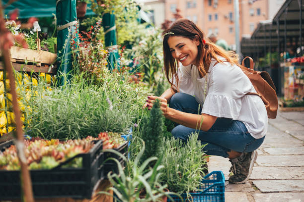 istock Young woman looking at flowers 973099268