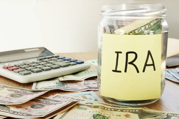 istock IRA written on a stick and jar with dollars. 973099588
