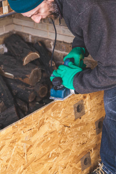 istock man scratches wood plate with electric plane 973100418