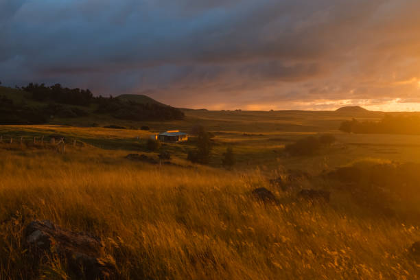 Sunrise in the fields of Easter Island with a tipical house and a volcano in the back