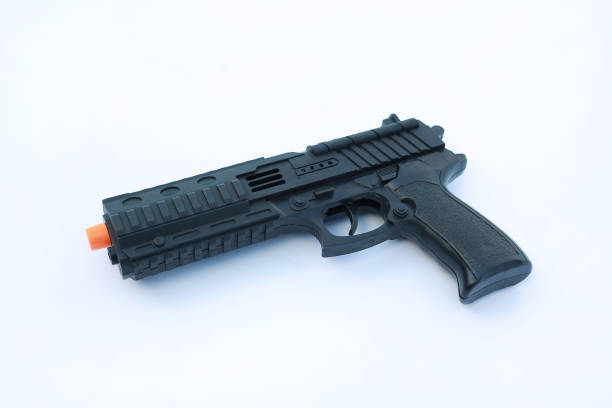 istock Black plastic toy hand gun on white background. 973104004