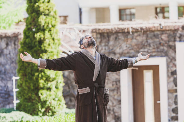 istock man in robe is standing in courtyard on summer morning 973108256