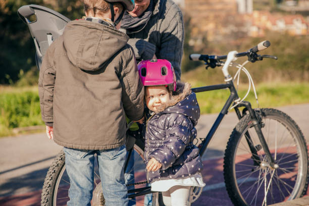 istock Children looking their father while repairing bicycle tire 973108922
