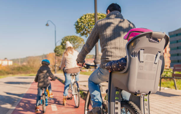 família com crianças montar bicicletas na natureza - adult couple four people urban scene - fotografias e filmes do acervo