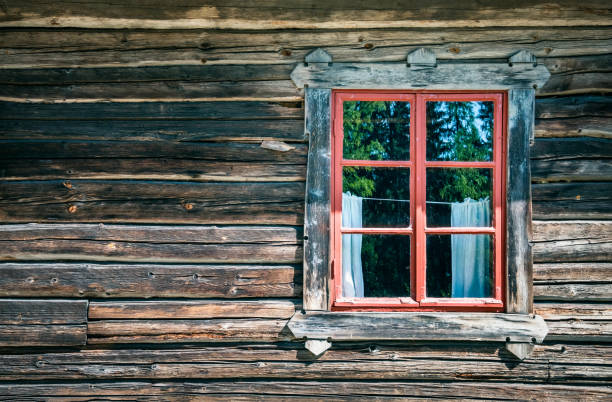 Old and worn timber wall with window at abandoned cottage.