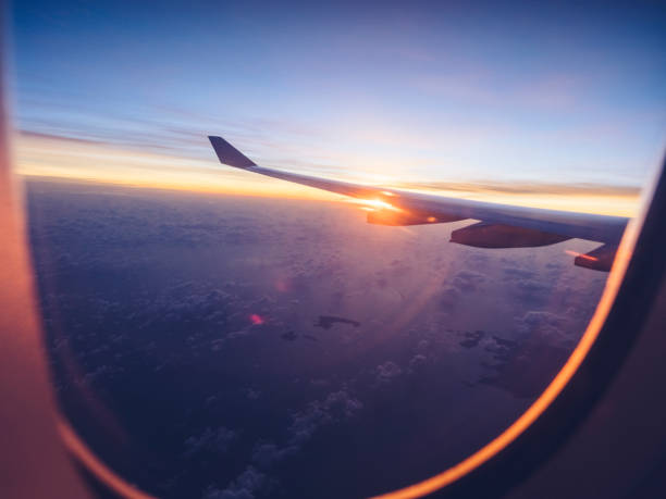 above clouds with aircraft wing at sunset - wing airplane window sunset imagens e fotografias de stock