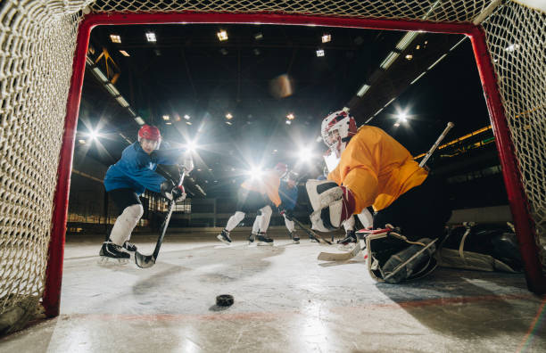 istock Ice hockey player scoring while playing the match at ice hockey rink. 973115272