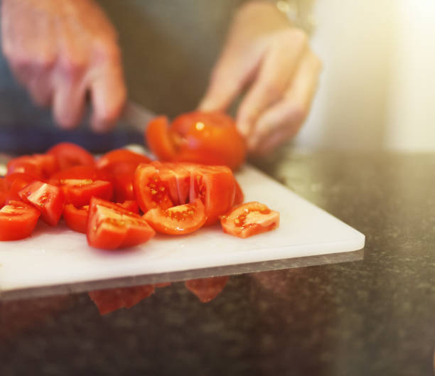 homem corta tomates - lifestyles domestic kitchen human hand furniture - fotografias e filmes do acervo