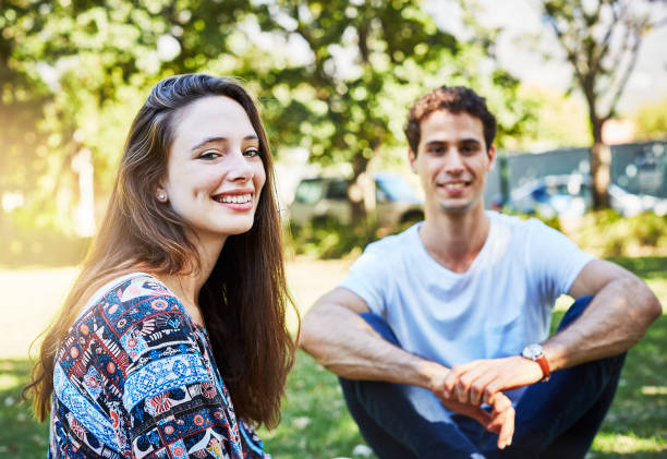 istock Young couple sitting in sunny park, relaxing 973117142