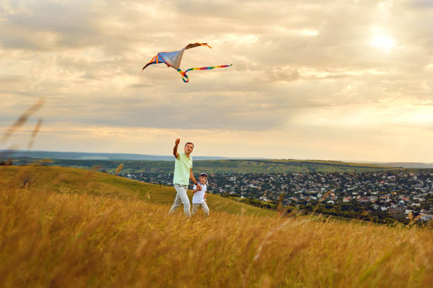 istock Father and son playing with a kite in nature 973121944