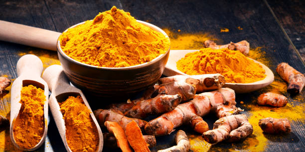 istock Composition with bowl of turmeric powder on wooden table 973139048