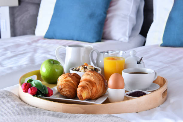 istock Breakfast on tray in bed in hotel room 973141190