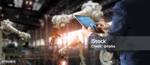 Manager Industrial Engineer Using Tablet Check And Control Automation Robot Arms Machine In Intelligent Factory Industrial On Real Time Monitoring System Software Welding Robotics And Digital Manufacturing Operation Industry 40 Concept Stock Photo - Download Image Now