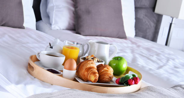 istock Breakfast on tray in bed in hotel room 973147548