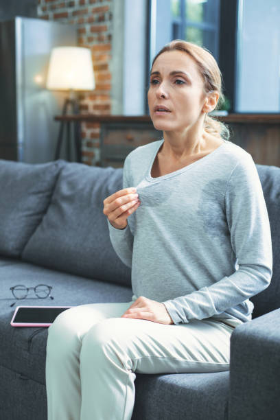 istock Sad mature woman suffering from hot flashes 973159076