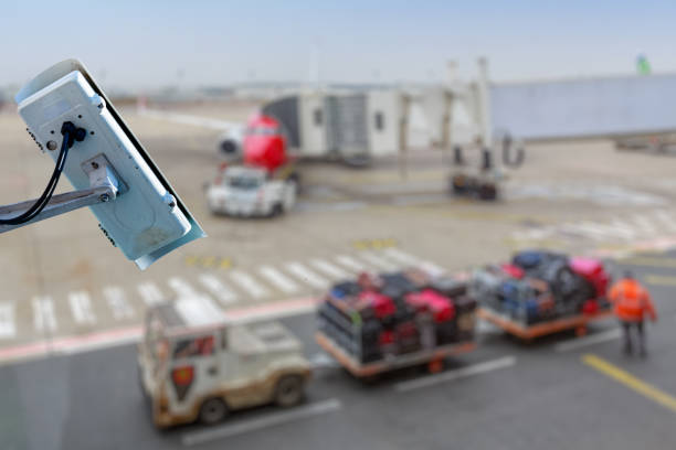 Focus on security CCTV camera or surveillance system with airport tarmac on blurry background