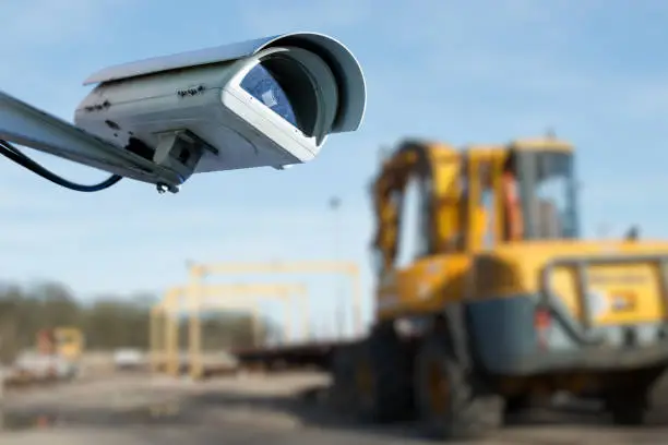 security CCTV camera or surveillance system with industrial site on blurry background