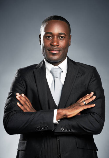 istock Handsome African-American businessman smiles with arms folded 973166002