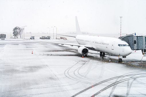 Horizontal color image of airplane during snowstorm.