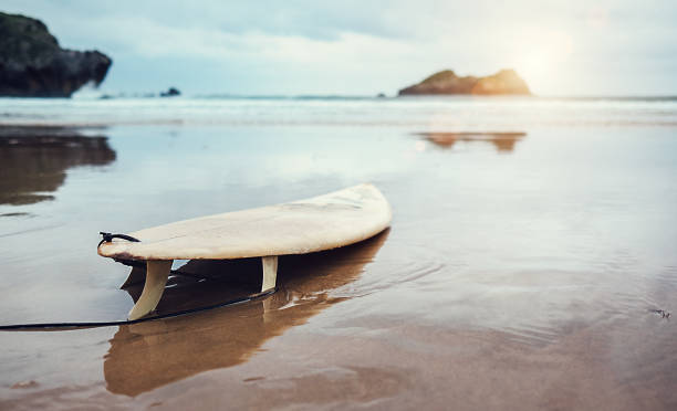 Board for surfing on deserted ocean beach Board for surfing on deserted ocean beach cantabria stock pictures, royalty-free photos & images