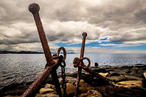 Old anchor on the rocks at St Tropez, France.