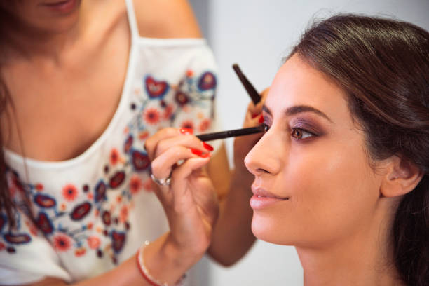istock Professional makeup artist working on a beautiful model in the studio 973181020