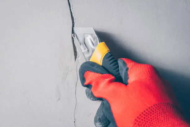 Working with a knife extends a crack in the wall