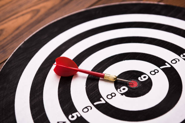 istock Darts with arrow on wooden background 973187338