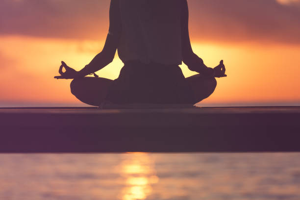 istock Young woman practicing yoga on the beach. 973191936