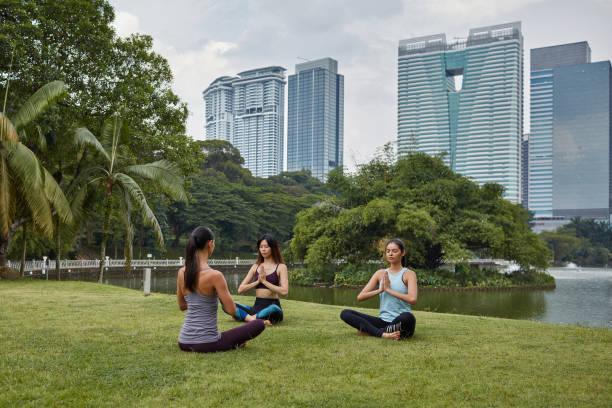istock Three multi-ethnic young women doing yoga at park 973194668