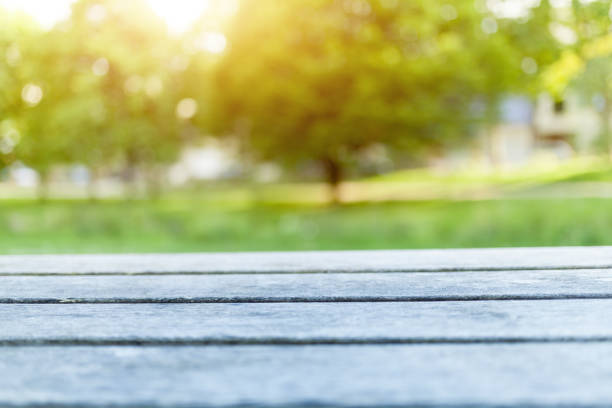 istock Empty wooden table with blurred city park on background 973195762