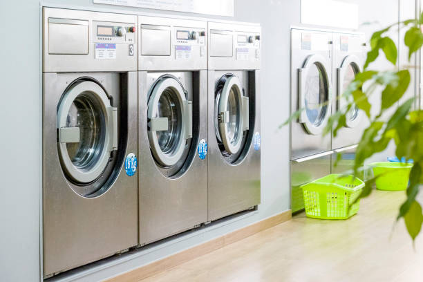 Public laundry with modern, silver washing machines Public laundry with modern, silver washing machines in a row laundry stock pictures, royalty-free photos & images