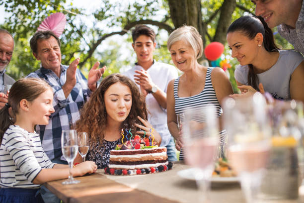 Family celebration or a garden party outside in the backyard. Family celebration outside in the backyard.Big garden party. Birthday party. A teenage girl with a birthday cake. birthday wishes for daughter stock pictures, royalty-free photos & images