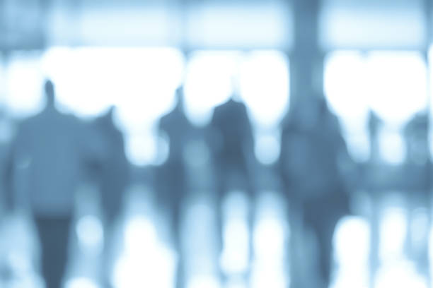 Business people abstract background Business corporation abstract background - blurred corridor in a corporate office or airport with people in motion (blue filter effect) defocused office business motion stock pictures, royalty-free photos & images