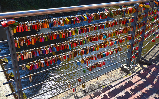 Lueneburg, Germany - June 5, 2018: Countless, colorful love padlocks hanging on a railing at the river Ilmenau in Lueneburg, Germany