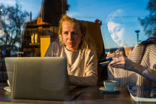 istock Female students reading something on laptop in cafeteria. 973215970