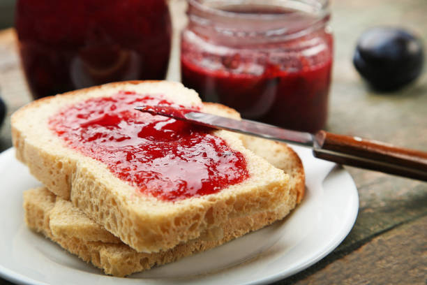 istock Bread with plum jam on grey wooden table 973216088