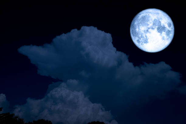 istock full blue moon and light blue heap cloud on night sky 973216126