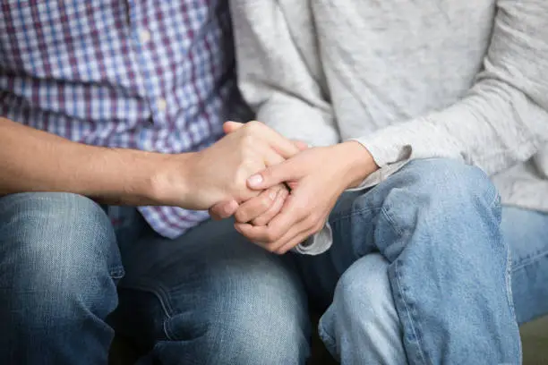 Photo of Support in marriage concept, close up of couple holding hands