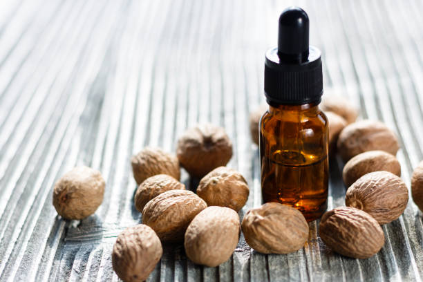 istock nutmeg essential oil on a gray wooden background 973225816