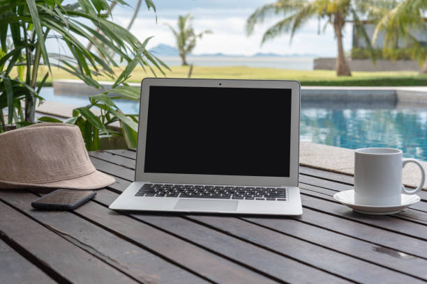 istock laptop and hat at the pool. 973257814